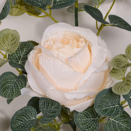 Vite di edera rosa con foglie verdi appese a ghirlande di fiori artificiali